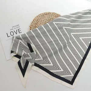 Black and white geometric print silk scarf detail, elegant triangle neckerchief for women.