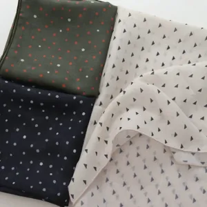 Detailed view of vintage patterned small square scarves featuring stylish polka dot and triangle designs.