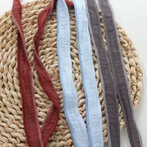 Close-up detail of lightweight colorful fabric straps with delicate stitched edges for versatile styling.