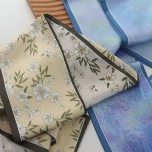 Gedetailleerd overzicht van de elegante zijden sjaal met bloemenprint en fijne textuur.