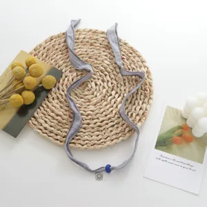 Chic grey fabric ribbon choker necklace with blue bead and sun pendant versatile jewelry.