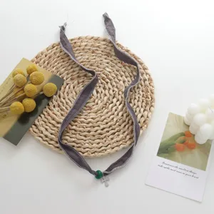 Minimalist fabric ribbon choker necklace with green bead and silver cross pendant chic.