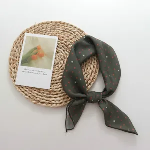Detailed view of dark green retro polka dot small square scarf with elegant floral postcard.