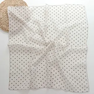 Detail view of soft cotton-linen small square scarf featuring geometric triangle print pattern.