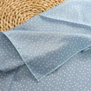 Close-up detail of blue polka dot imitation silk small square scarf, elegant neckerchief decor.