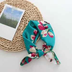 Detail view of the floral imitation silk small square scarf, elegant neck and hair accessory.