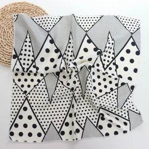 Black and white geometric polka dot silk scarf detail, elegant small square neckerchief.