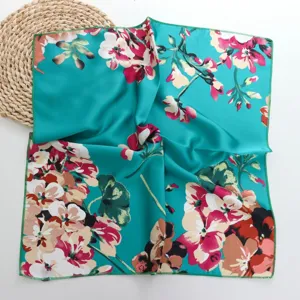 Detailed view of a turquoise floral silk square scarf, perfect for hair or neck styling.