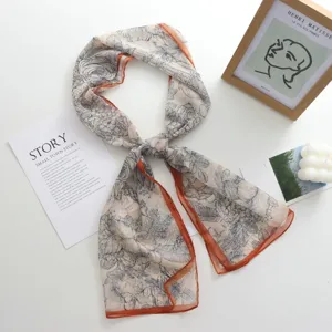 Long foulard élégant à imprimé floral avec bordure orange, accessoire d'été léger et chic.