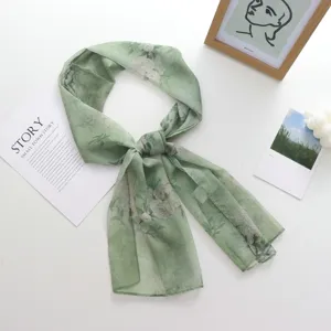 Détail d'écharpe en mousseline florale verte, tissu léger fin et élégant pour l'été.