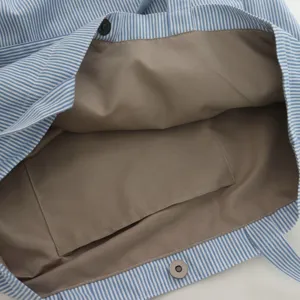Innenansicht der blau-weißen Canvas-Tasche mit braunem Futter und starkem Magnetverschluss.