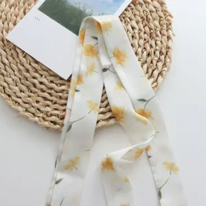 Détail de ruban en soie floral, élégant imprimé de fleurs jaunes, foulard délicat.