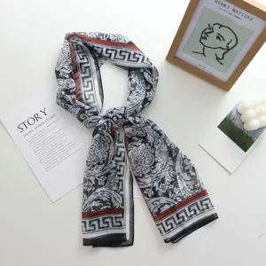 Élégant foulard long en soie pour femme avec imprimé floral baroque noir et blanc et bordure rouge.