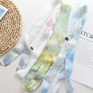 Ruban en soie multicolore pour cheveux et taille avec de délicats pendentifs métalliques.