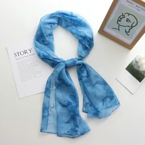 Élégant long foulard en mousseline bleue à motif floral, accessoire de protection solaire d'été élégant.