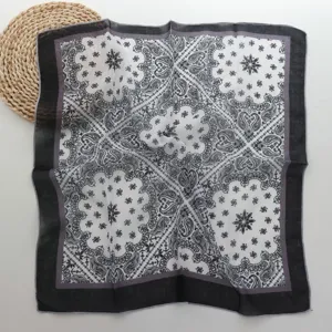 Primer plano detalle de la textura del pañuelo cuadrado de algodón lino paisley negro.