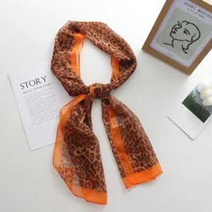 Écharpe longue en mousseline imprimé léopard avec bord orange, légère et élégante.