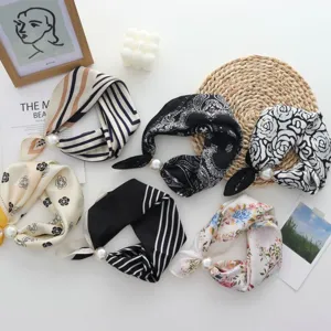 Vista dettagliata di eleganti foulard di seta stretti con chiusure magnetiche di perle.