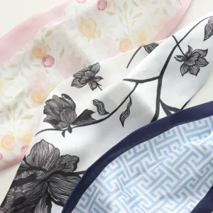 Silk scarf detail shot featuring floral print and geometric pattern for women's fashion wear.