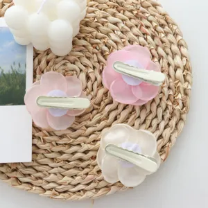 Close-up detail of lovely fabric flower hair clips with duckbill clip, aesthetic flat lay.
