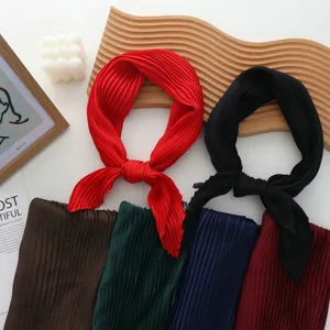 Detailed view of fashionable pleated square scarves in multiple colors, soft fabric for elegant wear.