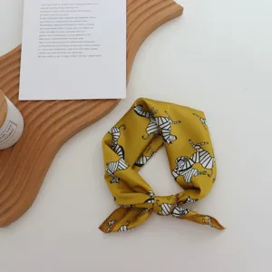 Gros plan d'un petit foulard carré en imitation soie jaune avec un imprimé zébré.