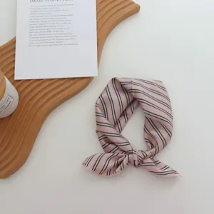 Vue détaillée du carré de soie rayé géométrique rose, parfait pour un style foulard.