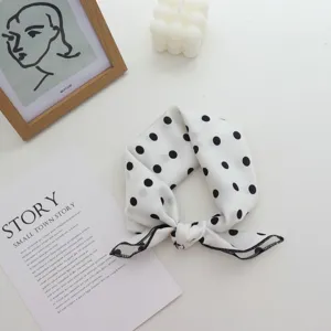 Detail chic de foulard de cheveux en soie à pois noirs et blancs, style élégant.