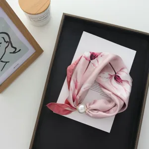Roze zijden sjaal detail met parel gesp, elegante halsaccessoire en stijlvolle look.