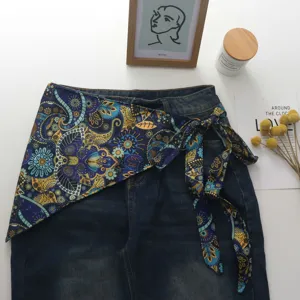 Λεπτομέλεια φούστας wrap από denim και μετάξι paisley, κομψός τριγωνικός σχεδιασμός σε στρώσεις.