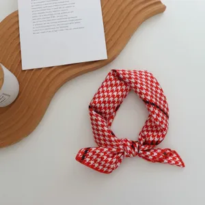 Vue détaillée du foulard en soie à motif pied-de-poule rouge et blanc, idéal pour les cheveux.