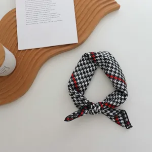 Vue détaillée d'un foulard en soie chic à motif pied-de-poule et bande rouge pour les cheveux.