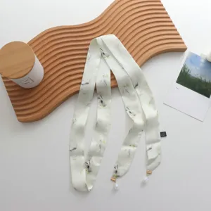 Écharpe longue et étroite en ruban de soie imprimé avec pendentif perle pour accessoire chic.