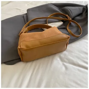 Retro bruine suède schoudertas detailopname, veelzijdige handtas voor forenzen met verstelbare riem.