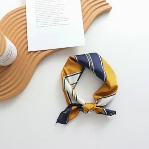 Vue détaillée du carré de soie à rayures géométriques, idéal pour cheveux ou foulard.