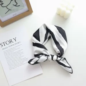 Détail de carré de soie à rayures noires et blanches, idéal comme foulard ou accessoire.