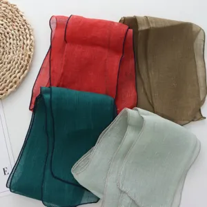 Detailed view of solid color long linen scarf ribbon with delicate fine border trim.