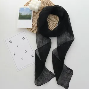 Close-up of elegant black long linen scarf, minimalist style, delicate texture and detail.