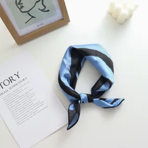 Vue détaillée d'un petit foulard carré en soie artificielle à rayures géométriques bleu et noir.