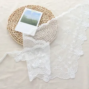 White lace floral embroidery trim close-up detail showcasing delicate fabric texture.