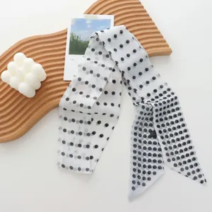 Detailed close-up shot of the elegant black and white polka dot skinny ribbon scarf.