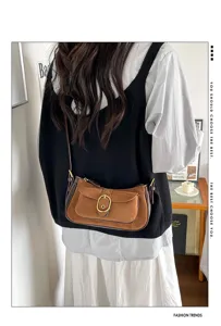 Retro suede crossbody bag detail showcasing contrast color design and metallic buckle.