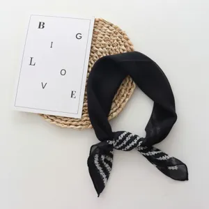 Detailed view of the black chiffon floral square scarf, elegant fabric texture and stylish knot.
