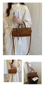 Vue détaillée d'un sac à main rétro en daim, avec boucles métalliques et bandoulière épurée.