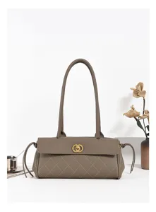 Detail view of grey quilted leather shoulder bag, featuring long handles and gold clasp.