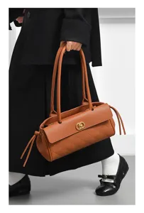 Detailed view of the stylish brown quilted shoulder bag with chic golden hardware and dual straps.