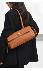 Brown quilted leather shoulder bag with golden lock clasp and long handle for women.