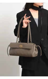 Close-up detail of the stylish quilted leather shoulder baguette bag with a chic golden clasp.