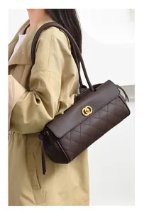 Detailed view of the vintage quilted brown leather shoulder bag with chic gold clasp and handle.
