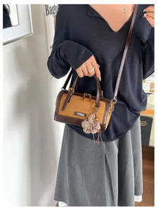 Vintage colorblock boston bag detail shot, chic shoulder and handbag with knit flower charm.